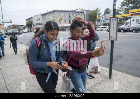 Une fille s'amusant dans la rue selfies après l'école à Brooklyn, New York Banque D'Images