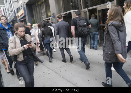 Les gens au travail à pied le long de la 8e Avenue près de la 34e rue pendant l'heure de pointe du matin à Manhattan, New York City. Banque D'Images