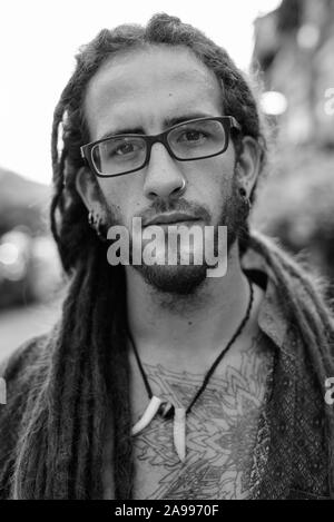 Beau jeune homme avec des dreadlocks touristiques Hispanique à l'extérieur en noir et blanc Banque D'Images