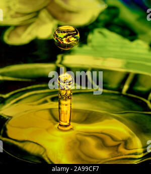 Deux gouttes d'eau transparent reflétant l'entourant en vert et jaune motif floral. Art de chute, l'eau goutte photography Banque D'Images