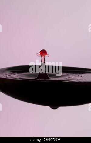 Les gouttes d'eau colorée publié à l'heure précise à entrer en collision et une forme - un parapluie dans une cuillère à soupe Banque D'Images