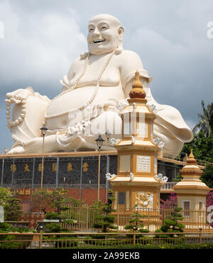 Assis Géant Bouddha souriant portant des perles à Vinh Trang Chua temple près de My Tho au Vietnam. Banque D'Images