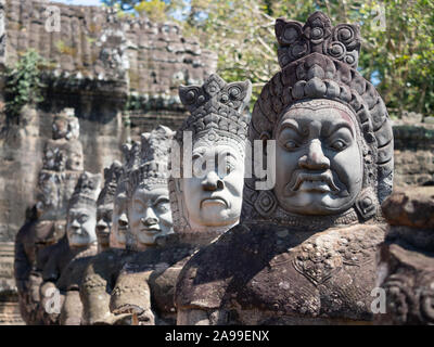 Rangée de Dieu démon et statues sur la chaussée à l'entrée d'Angkor Thom au Cambodge. Banque D'Images