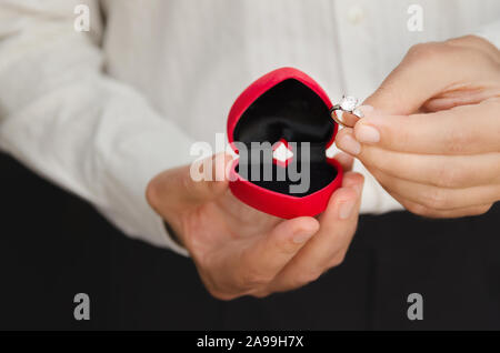 Man holding heart shape box avec anneau de mariage faire de proposition de mariage à Saint Valentines Day. Proposition et love concept. Banque D'Images