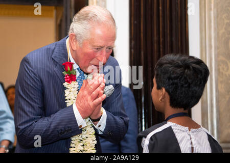 Le Prince de Galles reçoit une guirlande de fleurs d'un schoolboyduring la réception d'une fiducie d'Asie à Mumbai, le deuxième jour de la visite royale à l'Inde. Banque D'Images