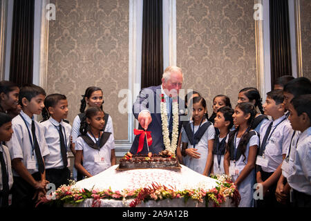 Le Prince de Galles coupe un gâteau d'anniversaire aux côtés des enfants de l'école au cours d'une réception de la Fiducie d'Asie à Mumbai, le deuxième jour de la visite royale à l'Inde. Banque D'Images