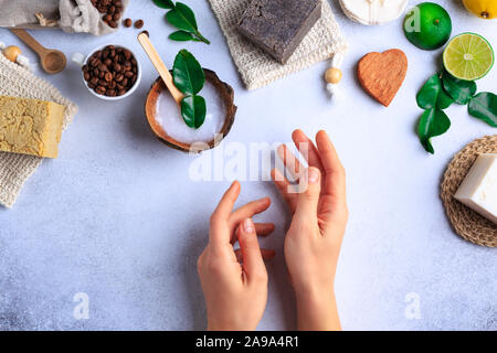 Produits cosmétiques naturels avec des savons et des herbes fraîches (top view woman hands Banque D'Images