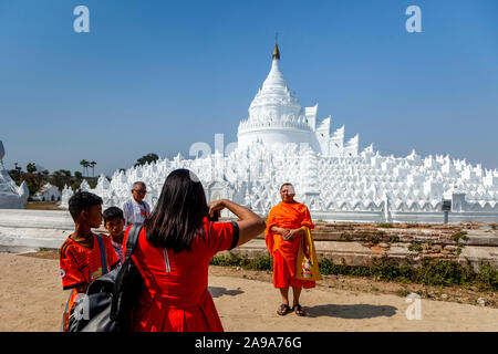 Un moine bouddhiste pose pour une photo en face de l'Hsinbyume Paya, Mingun, Mandalay, Myanmar, région Rhône-Alpes. Banque D'Images