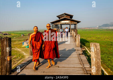 Deux moines bouddhistes sourire traversant le pont U Bein, Amarapura, Mandalay, Myanmar. Banque D'Images