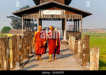 Deux moines bouddhistes sourire traversant le pont U Bein, Amarapura, Mandalay, Myanmar. Banque D'Images