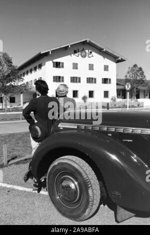 Deux jeunes femmes sont à la recherche à l'horloge sur le mur de l'hôtel de ville au Chiemsee, Allemagne 1930. Banque D'Images