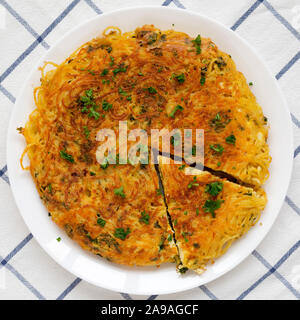 Spaghetti maison omelette sur une assiette blanche, vue du dessus. Mise à plat, les frais généraux, d'en haut. Close-up. Banque D'Images