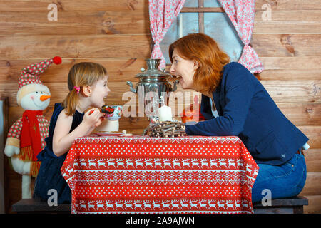 Maman et sa fille parler et boire du thé d'un samovar Banque D'Images