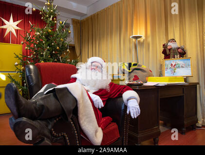 Flensburg, Allemagne. 14Th Nov, 2019. Santa Claus est assise sur un fauteuil à côté de son bureau au bureau de poste de Noël. Le Père Noël veut répondre à lettres d'enfants de partout dans le monde d'ici jusqu'à la veille de Noël. Jusqu'à présent environ 6000 lettres sont arrivés au bureau de poste. Credit : Soeren Stache/dpa-Zentralbild/dpa/Alamy Live News Banque D'Images