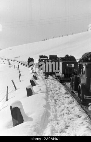 La circulation automobile dans un paysage d'hiver enneigé, Allemagne 1930. Banque D'Images