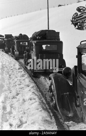 La circulation automobile dans un paysage d'hiver enneigé, Allemagne 1930. Banque D'Images