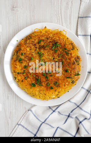 Spaghetti maison omelette sur une assiette blanche sur fond de bois blanc, vue du dessus. Mise à plat, les frais généraux, d'en haut. Banque D'Images