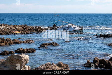 Cala Ratjada Mallorca une triste fin pour un yacht qui est casse sur les rochers comme les vagues d'autres dommages le yacht. Banque D'Images