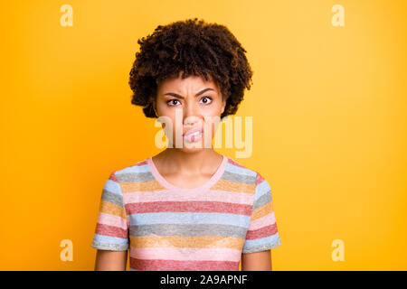 Photo gros plan de la peau sombre jolie dame bouclés à l'expression scandalisé les skateurs, avec tout ce monde à porter des rayures élégantes occasionnels t-shirt isolated Banque D'Images