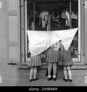 Trois jeunes filles, recouvert d'un rideau, avoir un regard dans une vitrine, Allemagne 1959 Banque D'Images