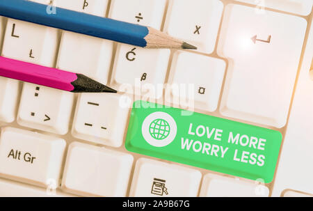 Écrit remarque montrant l'amour plus inquiéter moins. Concept d'affaires pour avoir une bonne attitude motivation être aimable profitez avec clavier pc blanc note pape Banque D'Images