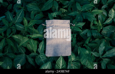 Maquette blanche , Sac de coton sur fond vert feuillage arbres Bush. Nature Eco Friendly Style. La préservation de l'environnement Recyclage Conce Banque D'Images