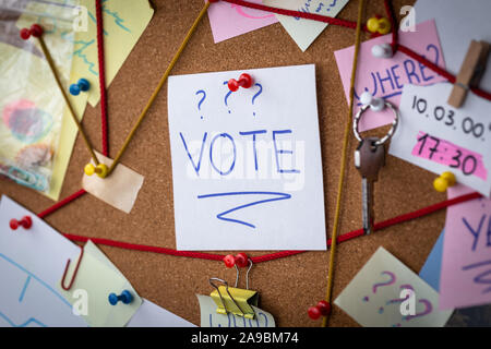 Concept de vote. Vue rapprochée d'un détective conseil la preuve. Dans le centre est une feuille blanche avec une broche rouge avec le texte mis aux voix. Banque D'Images