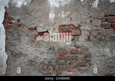 Vieux Mur en ruine avec collage hors de fragments de briques et ciment Banque D'Images