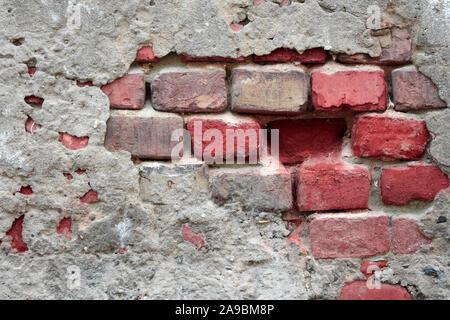 Vieux Mur en ruine avec collage hors de fragments de briques rouges et de ciment Banque D'Images