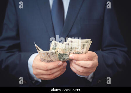 Homme en costume compte billets polonais. Affaires et finance, concept de salaire Banque D'Images