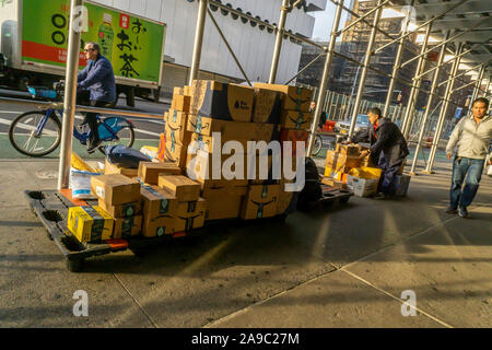 Un livreur sortes achète de l'aime de Amazon, tablier bleu, et d'autres dans le quartier de Greenwich Village de New York Lundi, Novembre 11, 2019 . (©ÊRichard B. Levine) Banque D'Images