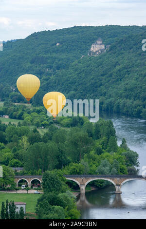 Deux ballons à air chaud jaune voler au-dessus de la rivière Dordogne avec chateau castlenaud dans l'arrière-plan Dordogne France Banque D'Images