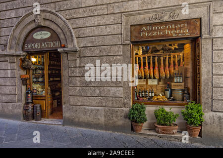 Magasin local pour la vente de jambon, du vin, du fromage et autres produits locaux sur la ruelle médiévale à Sienne, Toscane, Italie Banque D'Images