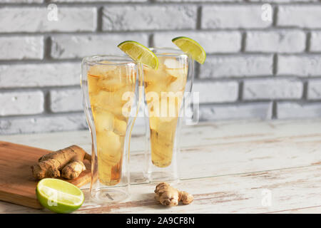 Bière au gingembre frais avec de la chaux et de glace ou Kombucha en bouteille - gingembre et citron Maison boisson probiotique bio, copiez l'espace. Banque D'Images