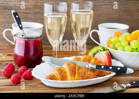 Table du petit déjeuner avec pain, fruits et champagne Banque D'Images