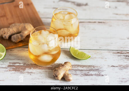 Bière au gingembre frais avec de la chaux et de glace ou Kombucha en bouteille - gingembre et citron Maison boisson probiotique bio, copiez l'espace. Banque D'Images