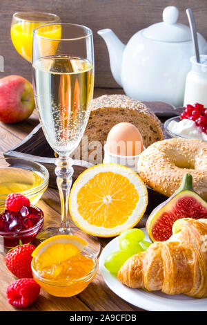 Table du petit déjeuner avec pain, fruits et champagne Banque D'Images