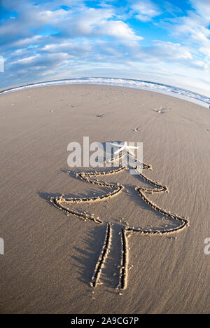 Vue grand angle de l'arbre de Noël simple dessiné dans le sable décorées de blanc délicat de cime starfish Banque D'Images
