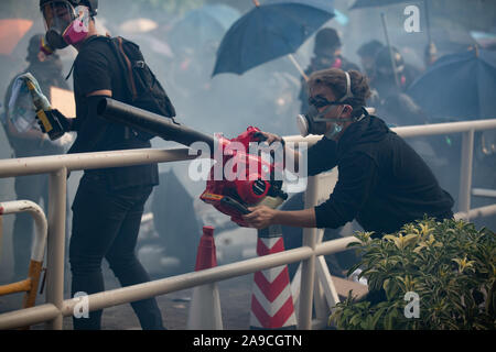 Élève à l'aide d'une souffleuse à feuilles de souffler la fumée de gaz lacrymogènes lors des manifestations sans précédent.les batailles de l'Université chinoise de Hong Kong (CUHK) que Hong Kong les manifestations se poursuivent pour le cinquième mois. Une grève à l'échelle de la ville a appelé à commencé le 11 novembre, 2019 et a parties de Hong Kong pour arrêter comme stations de métro fermées et plusieurs barrages routiers ont été érigés. Banque D'Images