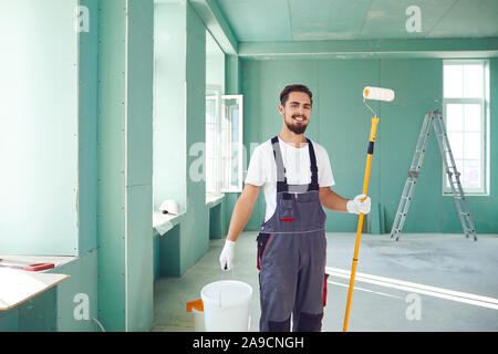 Peintre barbu travailleur de la construction sur un chantier de construction. Banque D'Images