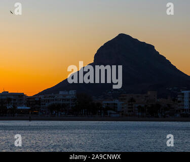 Un coucher de soleil sur la montagne Montgo, dans la belle ville côtière de Javea en Espagne. Banque D'Images