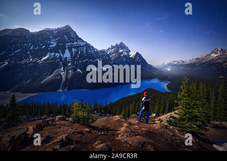 À l'aventurier le Lac Peyto dans la nuit, sous la lune. Le lac bleu et la neige sur les sommets. Rocheuses canadiennes, l'Alberta. Banque D'Images