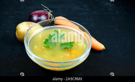 Soupe de légumes sur le fond noir et la carotte,oignon, pomme de decor Banque D'Images