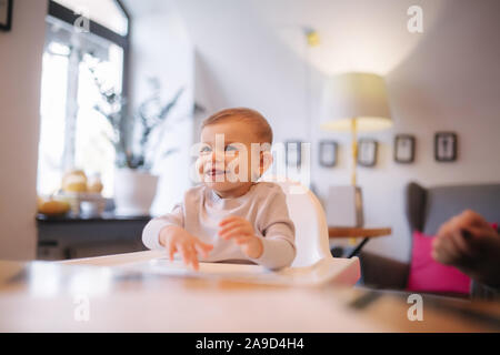 Portrait de l'adorable petite fille sur une chaise haute. Bébé rire et jouer. Happy girl smile Banque D'Images