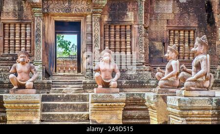 Des statues de figures humaines avec des têtes d'animaux à l'entrée de la 10e siècle temple de Banteay Srei à Angkor Wat à Siem Reap, Cambodge. Banque D'Images