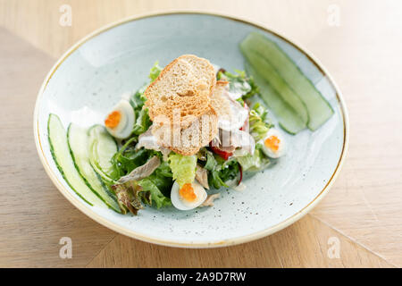 Langue d'agneau avec salade Olivier, salé concombre, oeuf de caille. Arrière-plan de table en bois. Restaurant Menu. Salade traditionnelle russe Banque D'Images