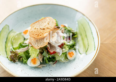 Langue d'agneau avec salade Olivier, salé concombre, oeuf de caille. Arrière-plan de table en bois. Restaurant Menu. Salade traditionnelle russe Banque D'Images