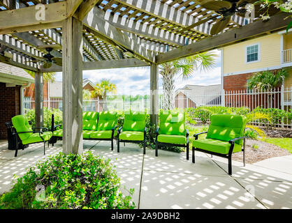 Chaises de Patio sont classés sous une pergola avec des ventilateurs de plafond, à Cypress Cove Maisons de vacances dans la région de Mobile, Alabama. Banque D'Images