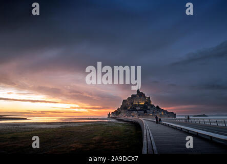 Le Mont-Saint-Michel au coucher du soleil et ciel dramatique Banque D'Images