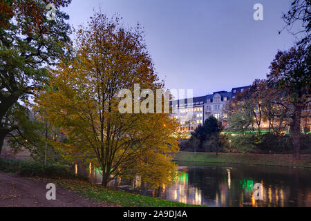 Les bâtiments résidentiels et commerciaux Strasse am Wall, arbres décolorés dans le Wallanlagen à l'automne au crépuscule, Bremen, Germany, Europe Banque D'Images